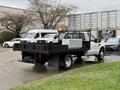 A 2008 Ford F-350 with a flatbed and toolbox in the truck bed is parked at a lot with vehicles in the background