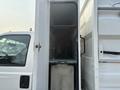 2009 Ford F-550 with an open side compartment revealing shelves and equipment storage inside