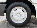 A white-painted truck wheel with a circular design and multiple bolts visible on the rim