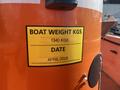 A yellow label on an orange boat indicating a weight of 1340 kgs and a date of April 2023