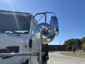 A close-up of a 2020 Peterbilt 330's side mirror and chrome details reflecting light