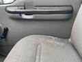 A worn gray fabric seat in a 2005 Ford F-350 SD with visible fraying and a small stain on the surface