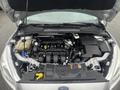 A 2018 Ford Focus with its hood open revealing the engine bay featuring various components including the engine block and fluid reservoirs