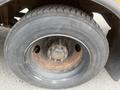 A close-up view of a rusted wheel and tire from a 2007 Freightliner B2 showing lug nuts and wear on the tread