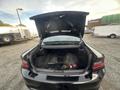 A 2015 Dodge Charger with its trunk open, revealing a spacious interior without visible cargo or items inside