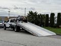 A 2022 Ford F600 tow truck with a flatbed ramp lowered ready for loading vehicles