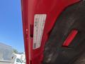 A red 2015 RAM 2500 truck with a visible label attached to the interior of the vehicle's door frame