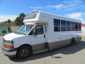 A white 2020 Chevrolet Express bus with large windows and a low step entrance designed for passenger transport