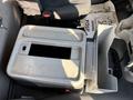 A metallic storage box is positioned in the cabin of a 2006 Freightliner M2 106 with an open compartment on top and a side panel for additional storage