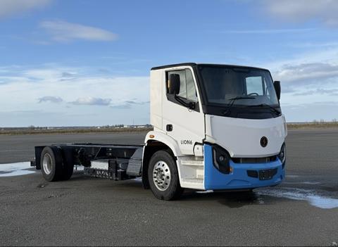 A 2022 Lion Lion6 truck cab with a white body and blue accents parked on a flat surface showcasing its modern design and structure