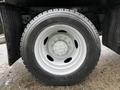 A close-up view of a silver wheel and tire on a 2021 Ford F-550 showcasing the tread pattern and wheel design