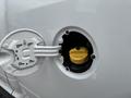 A yellow fuel cap inside a silver fuel filler door of a 2013 RAM 1500