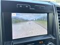 Screen display of a rearview camera in a 2019 Ford F-550 showing a view of the road ahead with surrounding scenery