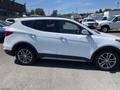 A white 2018 Hyundai Santa Fe is shown from the side highlighting its sleek design and alloy wheels
