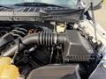 Engine compartment of a 2021 Ford F-150 showing the air intake hose and various engine components including the coolant reservoir
