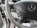 The steering wheel of a 2012 Mercedes-Benz Sprinter featuring controls for audio and cruise settings along with the Mercedes-Benz logo