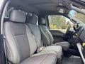 Interior of a 2020 Ford F-150 showing the front seats in gray fabric with a simple dashboard and steering wheel visible