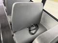 A row of gray seats inside a 2022 Freightliner B2 bus with seat belts visible on the seats
