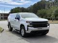A white 2019 Chevrolet Silverado 1500 with a sleek design featuring a large front grille and prominent Chevrolet logo parked at an angle