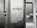 A close-up view of a metal winch labeled M12000 with specification details and warnings regarding its rating and usage