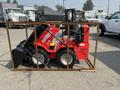 A red 2025 AGT Industrial SDA-140WZ compact loader with a front bucket is secured within a wooden frame