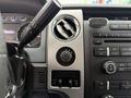 Instrument panel of a 2014 Ford F-150 featuring various controls dials and a radio display with buttons for audio functions