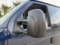 Close-up of the side mirror of a 2011 Ford Econoline van showing a black plastic design and the reflection of the interior