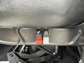 Close-up of two buttons on the interior of a 2016 Peterbilt 348 seat one red and one grey with icons for seat adjustment and seatbelt alert