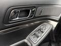 Interior door panel of a 2019 Ford Explorer featuring a silver handle controls for windows and mirrors and a textured surface