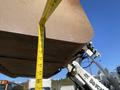 A close-up of a 2015 Bobcat 5600's bucket with a measuring tape extended vertically to show its height