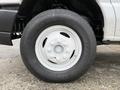 Close-up of a white wheel and tire from a 2019 Ford Econoline featuring a multi-bolt pattern and visible tread on the tire