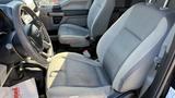 Interior view of a 2016 Ford F-150 showing two front seats and a part of the dashboard with controls and door panel visible
