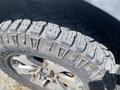 Close-up of a rugged tire from a 2014 Ford F-150 showcasing deep treads and a sturdy rim