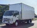 A white 2018 Hino 195 box truck with a large cargo area and an empty cab parked with a visible Budget logo on the side