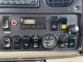 Dashboard controls of a 2013 Freightliner 114SD featuring various buttons switches and gauges for vehicle operation