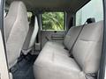 Interior seating of a 2010 Ford F-550 Super Duty featuring beige cloth upholstery with a spacious rear cabin area and seatbelt attachments