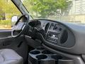 Interior view of a 2008 Ford Econoline with a dashboard featuring controls and a radio along with cup holders visible in the center console
