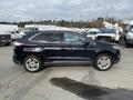 A 2017 Ford Edge in black with five-spoke alloy wheels, parked with its side profile facing the viewer