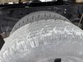 A close-up of a used tire showing worn tread and sidewall on a 2004 Ford F-350 SD