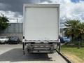 A 2022 International MV607 box truck viewed from the rear with a plain white cargo area and a hydraulic liftgate visible at the bottom