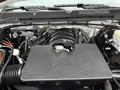 The image shows the engine compartment of a 2015 GMC Sierra 1500 with a black engine cover and various components including hoses and wires visible