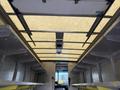 Interior view of a 2012 Ford Econoline van showing metal shelves and a light-colored ceiling with a vent and rolling covers