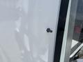 A close-up detail of a 2020 Chevrolet Express showing a small black knob attached to the vehicle's side panel