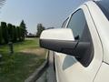 A side view of a white 2017 Chevrolet Silverado 1500 with focus on the driver's side mirror