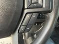 Close-up of the steering wheel controls in a 2020 Ford F-550 including buttons for volume mute and phone functions