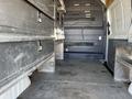 Interior of a 2010 Mercedes-Benz Sprinter with metal storage compartments along both sides and an empty cargo space in the center