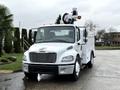 A 2005 Freightliner M2 106 utility truck with a white exterior featuring a bucket lift mounted on top and equipped with safety lights on the cab