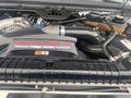 A 2005 Ford F-350 SD engine featuring a Power Stroke V8 turbo diesel label with visible components such as a large black air intake and various hoses and valves