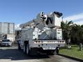 A white 2008 International 7500 bucket truck with an extended boom and a bucket on top for elevated work