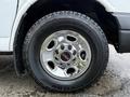 A close-up view of a chrome wheel rim with the GMC logo mounted on a rugged tire labeled Terramax A/T